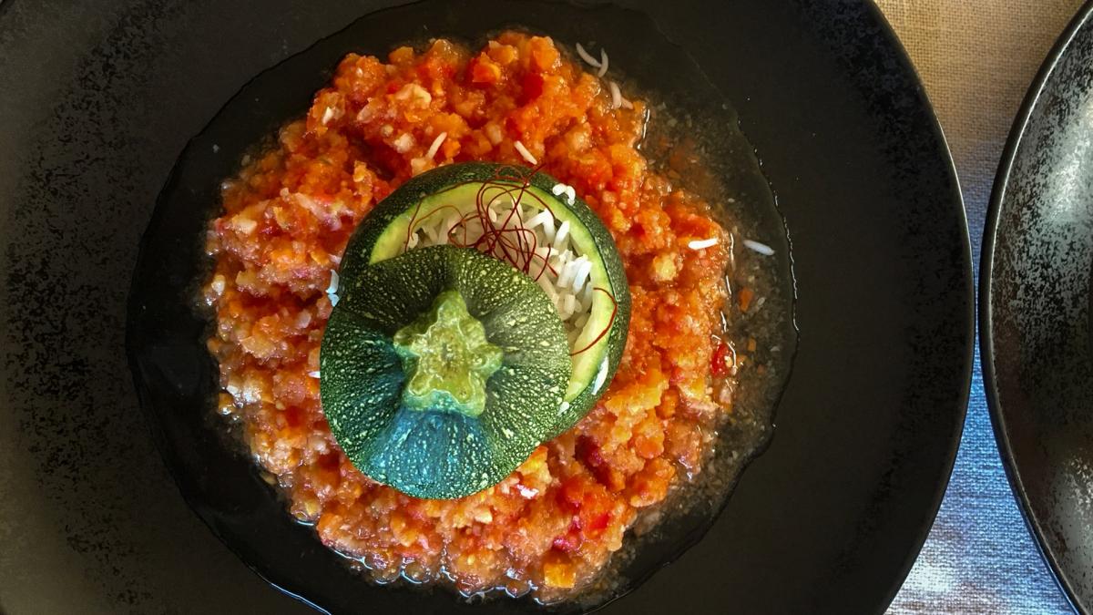 Zucchini Bolognese auf schwarzem Teller angerichtet
